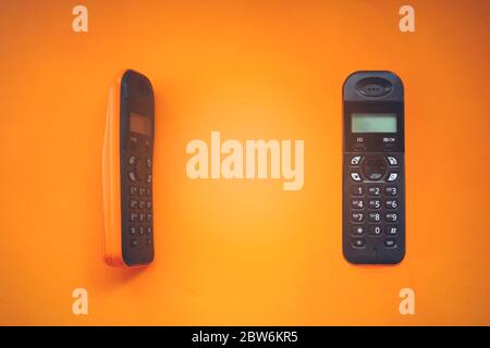 Two wireless cordless telephone, radiotelephone, dect cordless phone on orange background Stock Photo