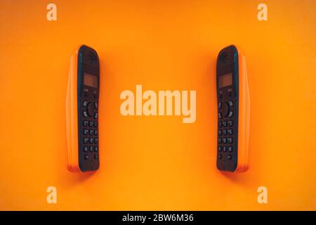 Two wireless cordless telephone, dect cordless phone wireless phone, radiotelephone, radio phone on orange background Stock Photo