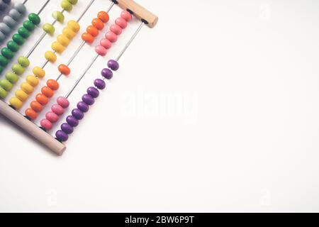 Multi-colored designer background. Calculating Colorful wooden rainbow abacus for number calculation. Close up wooden abacus on white background. Math Stock Photo
