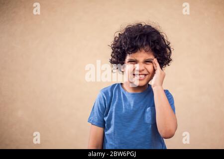Kid boy feels strong head ache. Children, healthcare and medicine concept Stock Photo