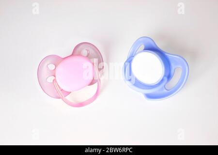 Pink and Blue Pacifiers on a white background. Two pacifiers close-up boy or girl isolated Stock Photo