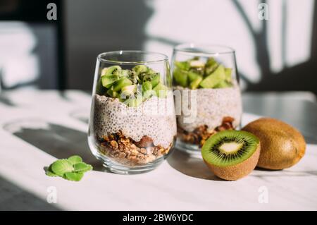 Healthy breakfast. chia pudding with kiwi and granola in glass on white background Stock Photo