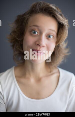 Portrait of young joyful lady looking in camera with wide-eyed Stock Photo