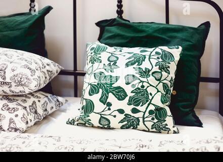 Set of various pillows with different natural ornaments and colors arranged on bed in modern apartment Stock Photo