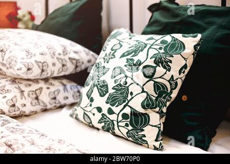 Set of various pillows with different natural ornaments and colors arranged on bed in modern apartment Stock Photo