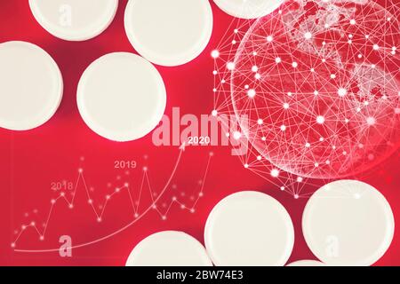 White medication pills lie with virtual hologram earth, statistics, graph and chart,on a red background. Medicine, pharmacy and healthcare. Empty spac Stock Photo