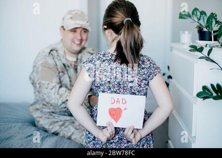 Happy father's day. Child daughter congratulates dad and gives him postcard. Family holiday and togetherness. Stock Photo