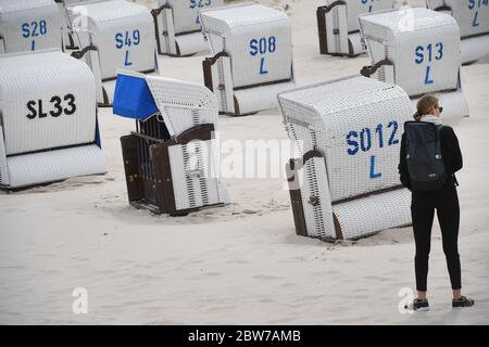Ahlbeck, Germany. 30th May, 2020. A woman is standing next to beach chairs on the beach of the Baltic Sea. Credit: Stefan Sauer/dpa-Zentralbild/dpa/Alamy Live News Stock Photo