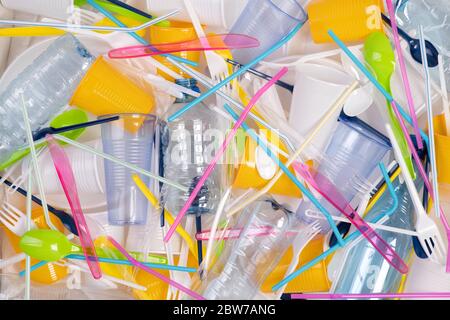Disposable single use plastic objects such as bottles, cups, forks, spoons and drinking straws that cause pollution of the environment Stock Photo