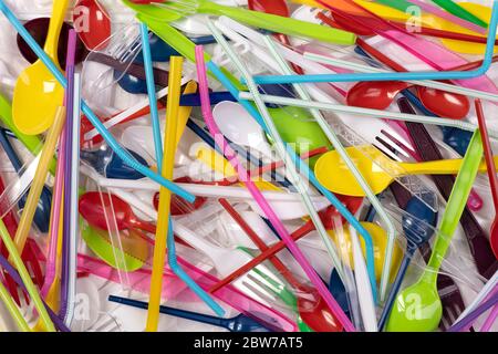 Disposable single use plastic objects such as bottles, cups, forks, spoons and drinking straws that cause pollution of the environment Stock Photo