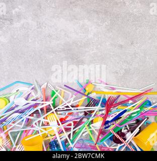 Disposable single use plastic objects such as bottles, cups, forks, spoons and drinking straws that cause pollution of the environment Stock Photo