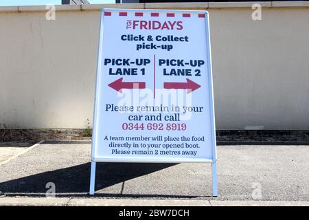Signs give instructions for Click & Collect customers at TGI Fridays restaurant in the Braintree Village shopping outlet during the COVID-19 pandemic Stock Photo