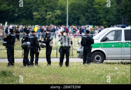 Munich, Germany. 30th May, 2020. Participants of a demonstration against the anti-Corona measures of politics stand and sit on the Theresienwiese at the prescribed distance. In the foreground are police officers. Credit: Sven Hoppe/dpa/Alamy Live News Stock Photo