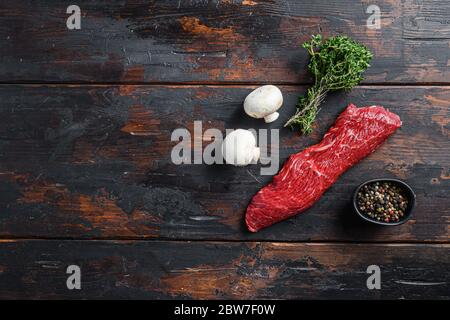 Tri tip steak with fresh seasoningsm thyme, for BBQ on wooden background, top view space for text. Stock Photo