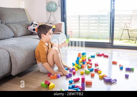 Bored child playing with blocks at home