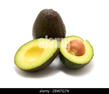 Fresh two avocado, one halved and one whole, over white background. Stock Photo