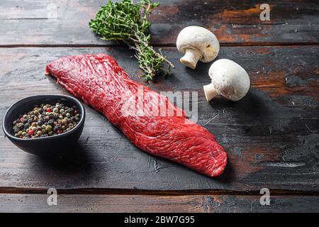 Tri tip steak with fresh seasoningsm thyme, organic tri-tip roast with fat marbled through the meat ready to roast or barbecue on rustic wooden backgr Stock Photo