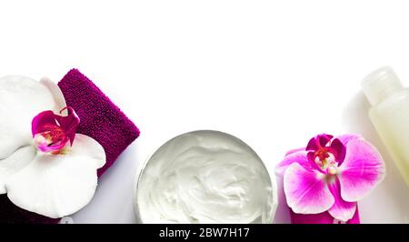 Soap, towel, cream and hygiene product, decorated with white and lilac orchid flowers on a white background. Spa concept Stock Photo