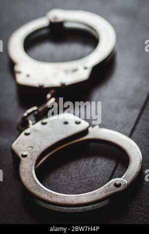 steel metal Handcuffs on brown background dark Stock Photo