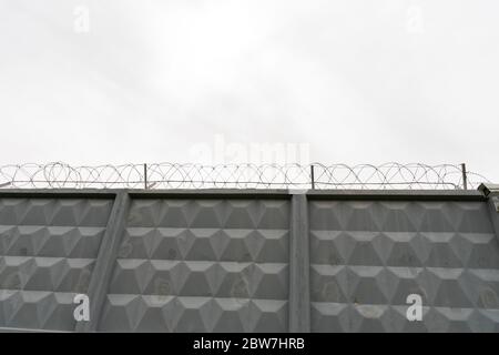 gray concrete wall with barbed wire. Gray background Stock Photo