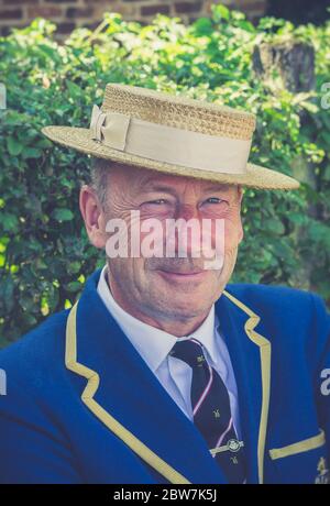 Front view close up of isolated 1940s man smiling in straw boater & school blazer, outdoors in summer at UK 1940s weekend WW2 event. Stock Photo