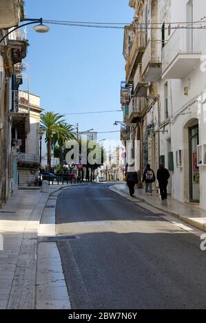OSTUNI, APULIA, ITALY - MARCH 28th, 2018: People walking in the street leading to Freedom Square of white city - Ostuni, Italy Stock Photo