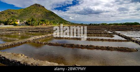 Tamarin Salt Pans is a popular tourist attraction with the square brick clay basins with beautiful mountain in the background. This place produces art Stock Photo