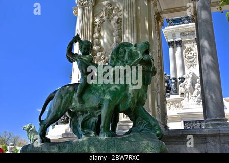 The statue of a small child riding a lion in the public Garden of Buen Retiro (The Jardines del Buen Retiro) Stock Photo