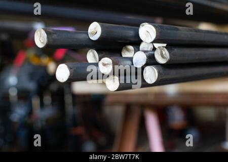 a close up of a bundle of steel round bar in a machine shop Stock Photo