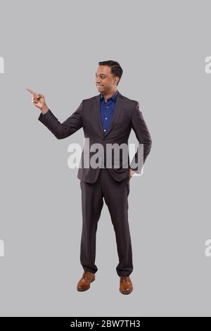 Businessman Pointing to Side Isolated. Indian Man Standing Full Lenght Stock Photo