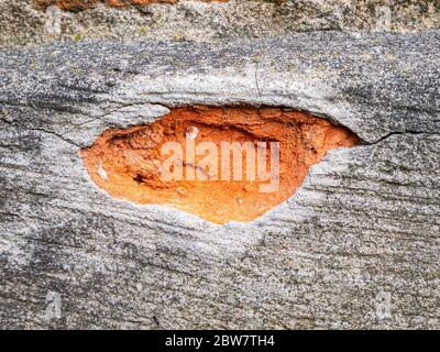 Chipped cement fragment of a red brick wall. Stock Photo