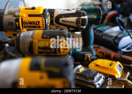 Maine, USA - May 13, 2020: Various cordless drills await use in a fabrication shop Stock Photo
