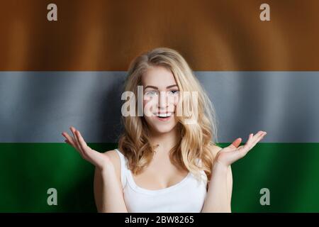 Beautiful happy young woman against the India flag background. Live, education and work in India Stock Photo