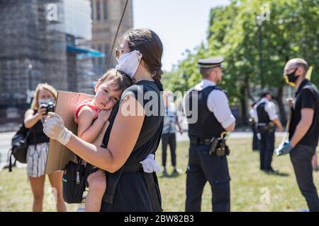Parliament Square, London, UK. 30 May 2020. A few hundred environmental campaigners from Extinction Rebellion demonstrate peacefully in Parliament Square. Protesters hold placards, demand decisive action from the UK Government on the global environmental crisis. Activists are standing and maintain appropriate social distancing. Police questions individual campaigners prompting them to move on; some are body searched and arrests follow for breach of Covid-19 regulations.