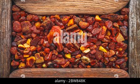 Amber stones framed in a wooden frame, background for design Stock Photo