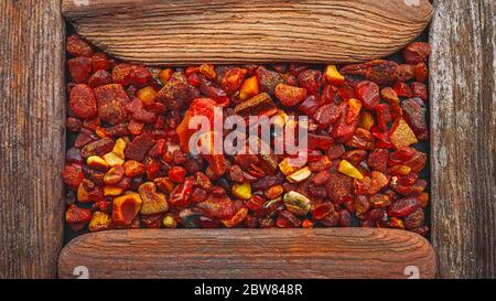 Amber stones framed in a wooden frame, background for design Stock Photo