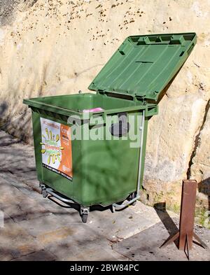 VALLETTA, MALTA - NOVEMBER 10TH 2019: A green rubbish bin stands open near the Valletta bus station. Ghalfejn thammeg pajjizek means Why tarnish your Stock Photo