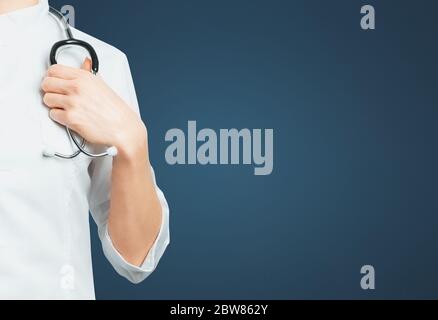 Unrecognizable Female Doctor In Medical Coat With Stethoscope on Blue Background. Medicine Insurance Healthcare Concept Stock Photo