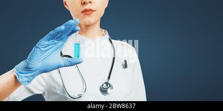 Unrecognizable Female Doctor Holds In Hand Ampoule With Vaccine, Selective Focus With Copy-space. Vaccination Healthcare Insurance Concept Stock Photo