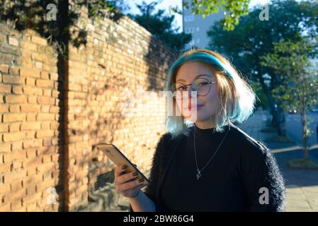 Young woman on an urban backgound in Brazil, posing in the city, natural and happy, confident and stylish Stock Photo