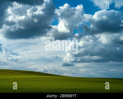 Dramatic sky over a green field Stock Photo