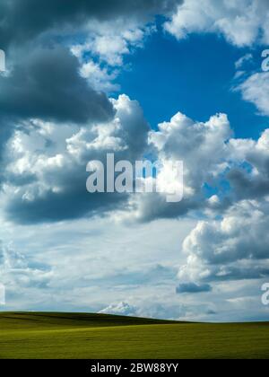 Dramatic sky over a green field Stock Photo