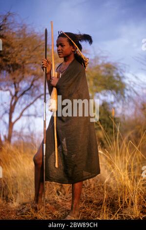 An African Teenaged Boy In Kenya Standing On The Beach With His Back To 