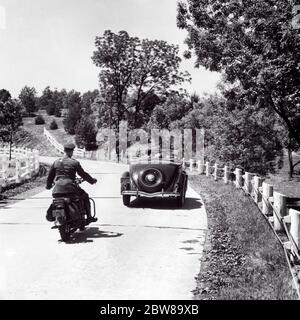 1930s 1940s MAN HIGHWAY PATROL POLICE OFFICER ON MOTORCYCLE PURSUING CONVERTIBLE CAR WITH COUPLE TWO PASSENGERS ON COUNTRY ROAD - m4762 HAR001 HARS POLICEMAN VEHICLE SAFETY LIFESTYLE SPEED FEMALES PASSENGERS RURAL COPY SPACE HALF-LENGTH HIGHWAY LADIES PERSONS AUTOMOBILE MALES RISK OFFICER TRANSPORTATION B&W COP PROTECT AND SERVE HIGH ANGLE ADVENTURE AUTOS EXCITEMENT REAR VIEW ON AUTHORITY OCCUPATIONS SPEEDING UNIFORMS PATROL CONCEPTUAL FROM BEHIND AUTOMOBILES VEHICLES OFFICERS POLICEMEN PURSUING BACK VIEW CHASING COOPERATION COPS TOGETHERNESS BADGE BADGES BLACK AND WHITE HAR001 OLD FASHIONED Stock Photo