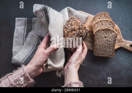 Woman's hands holding a loaf of multi seed bread Stock Photo