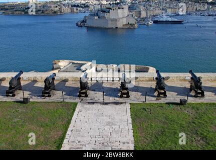 UPPER BARRAKKA GARDENS, VALLETTA, MALTA - NOVEMBER 10TH 2019: The cannons of the Saluting Battery points out towards Fort St Angelo across the harbour Stock Photo