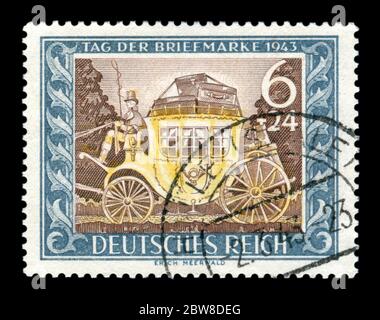 German historical stamp: A coachman on an old mail coach with suitcases at the top and the symbol of the post office. Postage stamp day issue 1943 Stock Photo