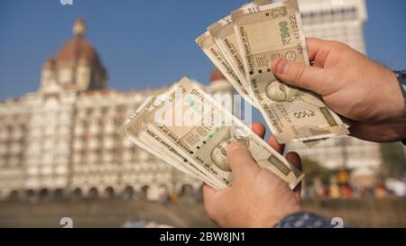 A man considers Indian 500 rupees on Mumbai street. Hands close up. Stock Photo
