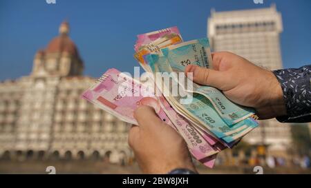 A man considers Indian rupees on the street of Mumbai. Hands close up. Stock Photo