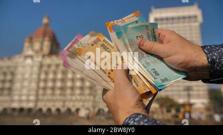 A man considers Indian rupees on the street of Mumbai. Hands close up. Stock Photo